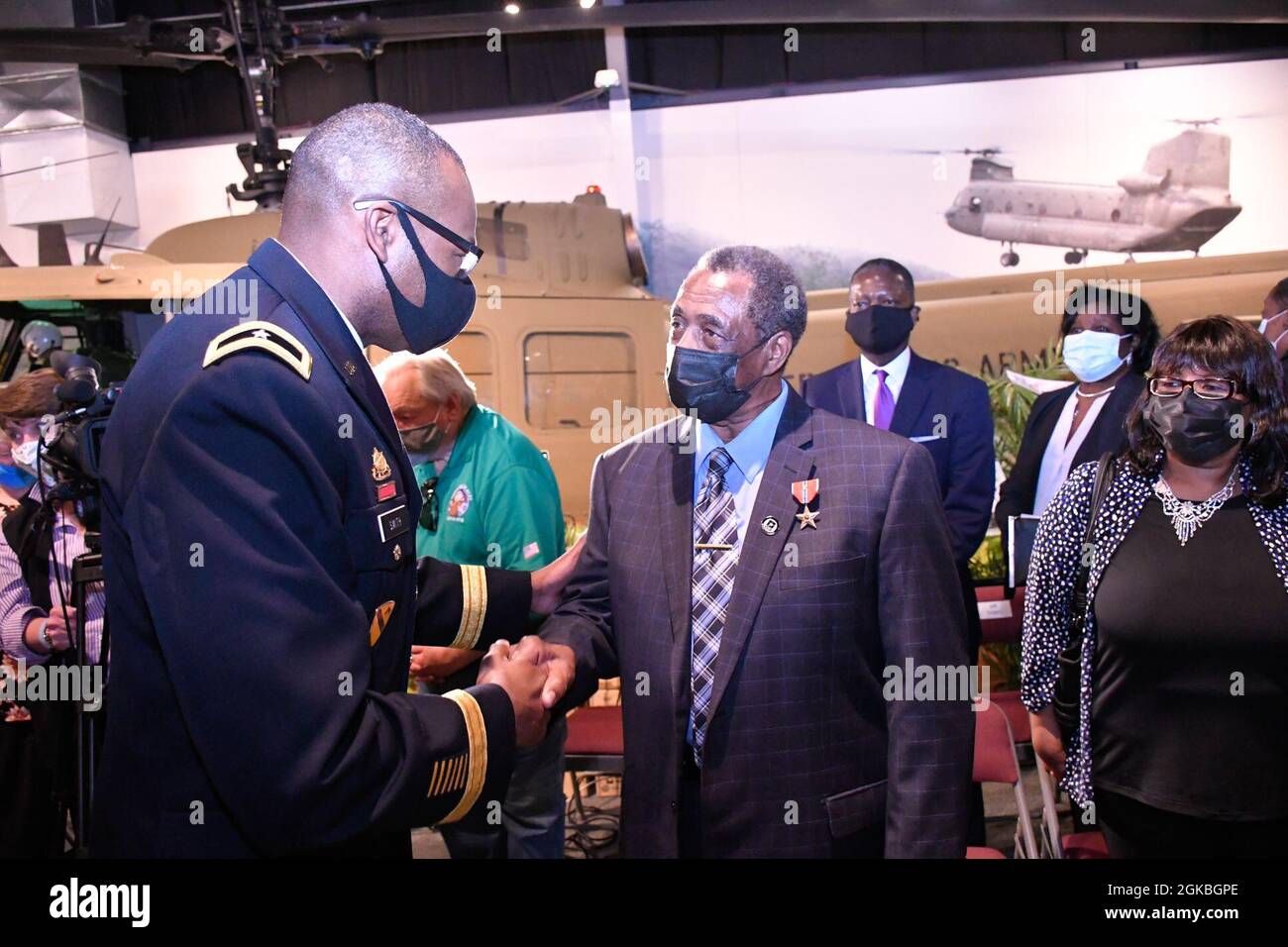 Brig. Gen. James Smith, Chief of Transporation, congratulates former Army Spc. Ronald Mallory after presenting him with the Bronze Star Medal with "V" device following a ceremony March 4 at the Army Transportation Museum. Stock Photo