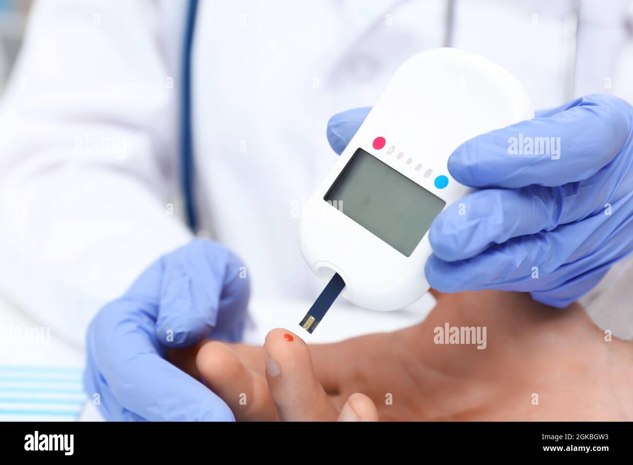 Doctor in latex gloves taking sample of patient's blood using digital