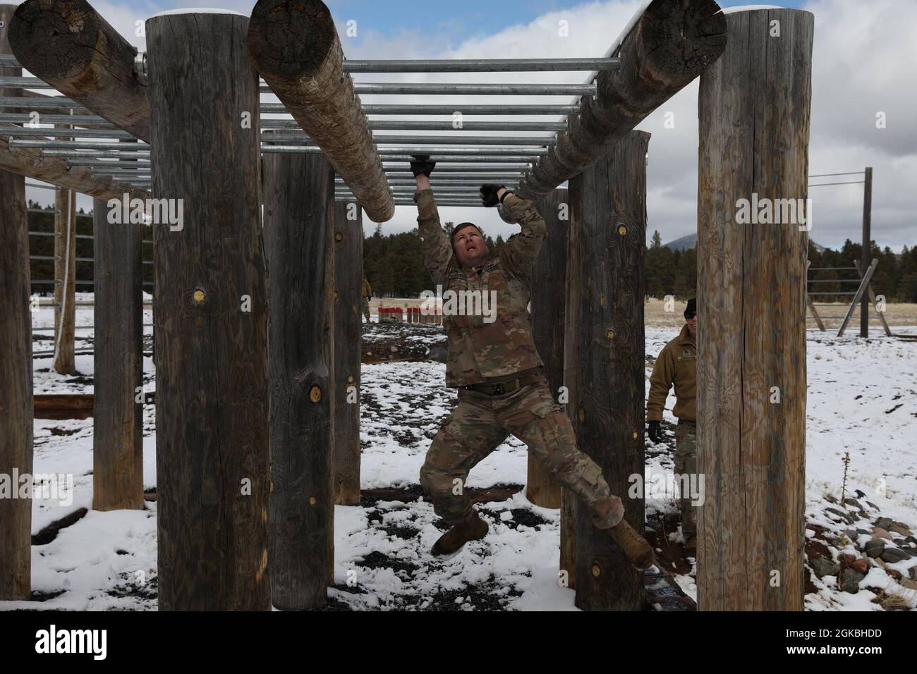 Chief Warrant Officer 2 Samuel Irons, 1348th Support Maintenance Company, Arizona Army National Guard, moves across the monkey-bar obstacle during the Obstacle Course event of the 2021 Arizona Best Warrior Competition at Camp Navajo, Bellemont, Ariz. on March 4.    The obstacle course event of the 2021 Best Warrior competition required the competitors to complete a series of physical obstacles to demonstrate their physical agility, toughness, and endurance along with their ability to mentally push themselves through the extreme fatigue that builds as they move through the course. Stock Photo