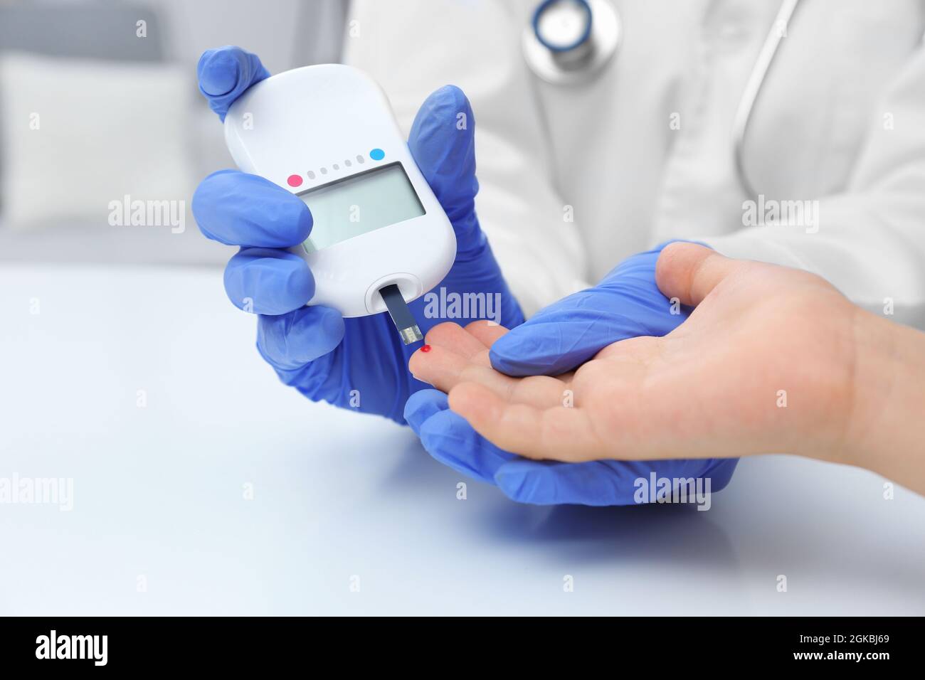 Doctor in latex gloves taking sample of patient's blood using digital