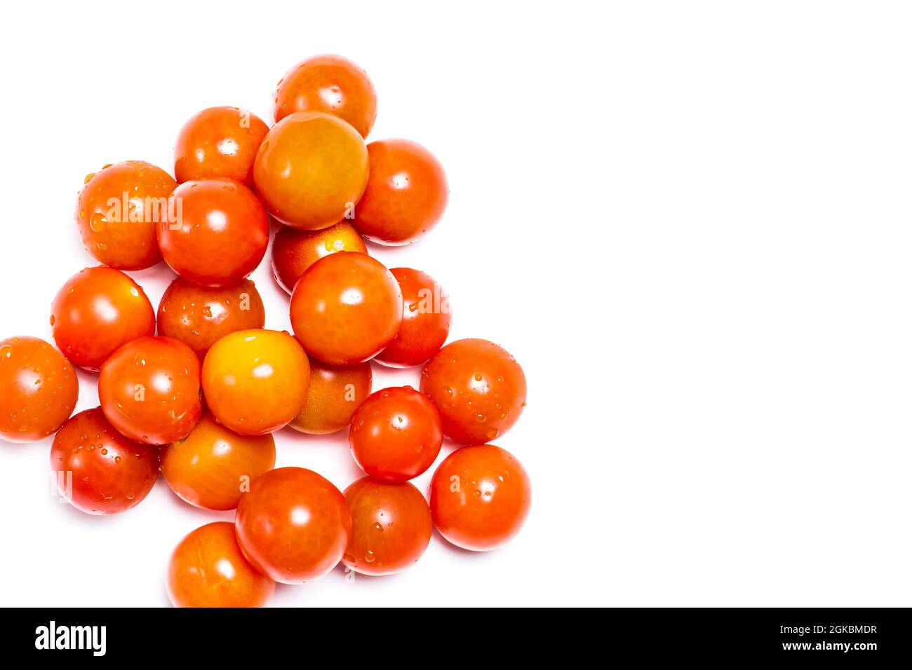 Overhead shot of tomatoes little ones natural reds on a white background. The photograph has copy space and is taken in horizontal format. Stock Photo