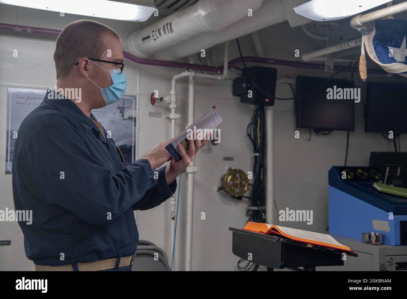 PACIFIC OCEAN (March 5, 2021) U.S. Navy Lt. Patrick Glynn, from Columbia, Miss., reads scripture during a service aboard the Ticonderoga-class guided-missile cruiser USS Bunker Hill (CG 52) March 5, 2021. Bunker Hill, part of the Theodore Roosevelt Carrier Strike Group, is on a scheduled deployment to the U.S. 7th Fleet area of operations. As the U.S. Navy’s largest forward-deployed fleet, 7th Fleet routinely operates and interacts with 35 maritime nations while conducting missions to preserve and protect a free and open Indo-Pacific Region. Stock Photo