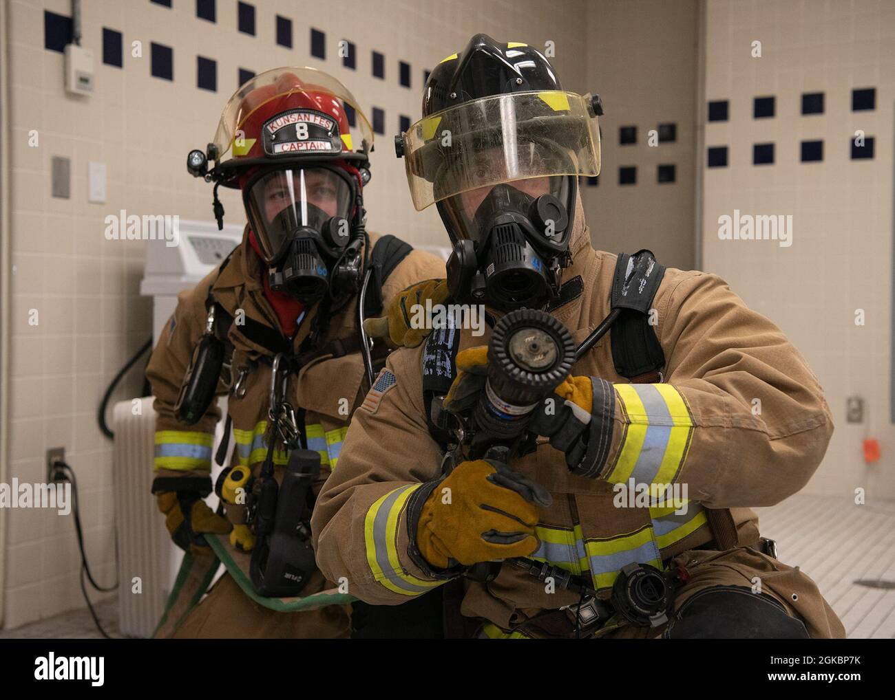 U.S. Air Force Senior Airman Thomas Ulric, 8th Civil Engineer Squadron firefighter lineman (right), and USAF Staff Sgt. John Cools, 8th CES firefighter crew chief (left), simulate fighting a fire in a high-rise building at Kunsan Air Base, Republic of Korea, 5 March 2021. Air Force firefighters train for speed and efficiency when performing regular firefighting exercises. Stock Photo
