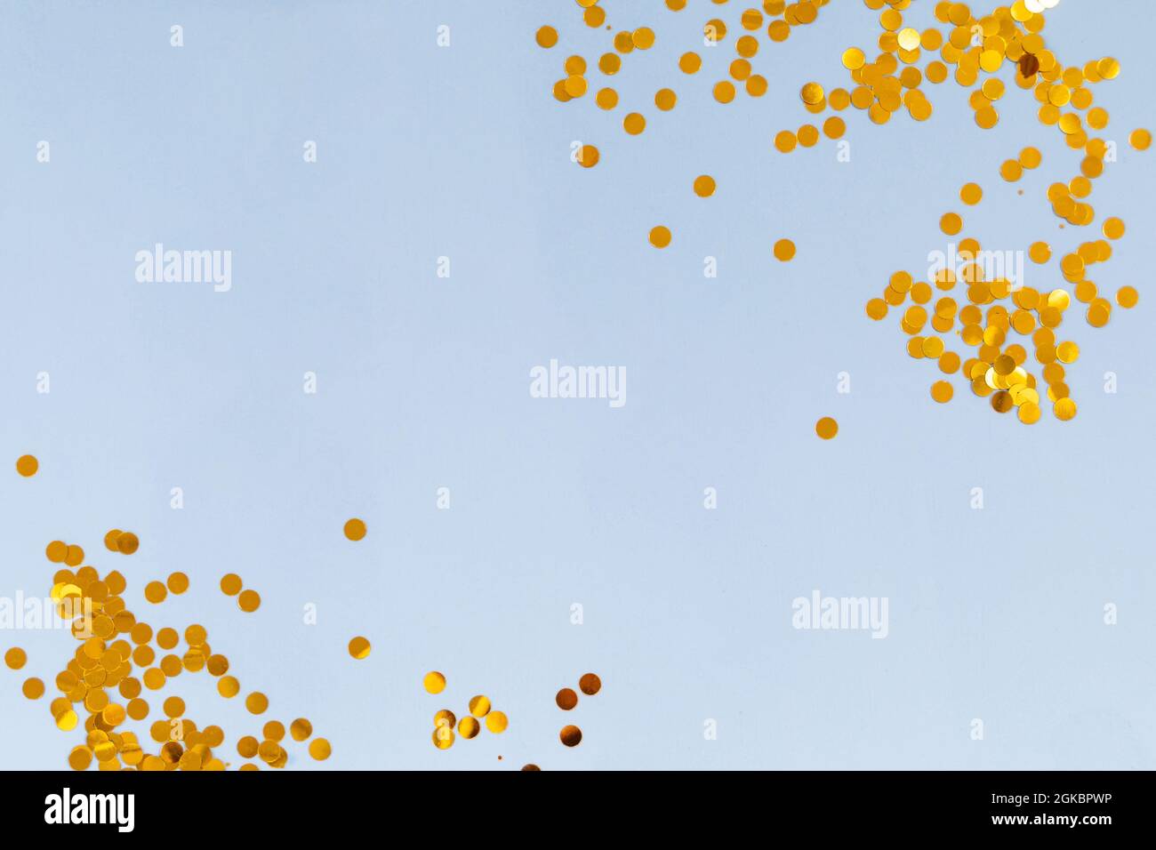 Light blue background with golden confetti, selective focus Stock Photo