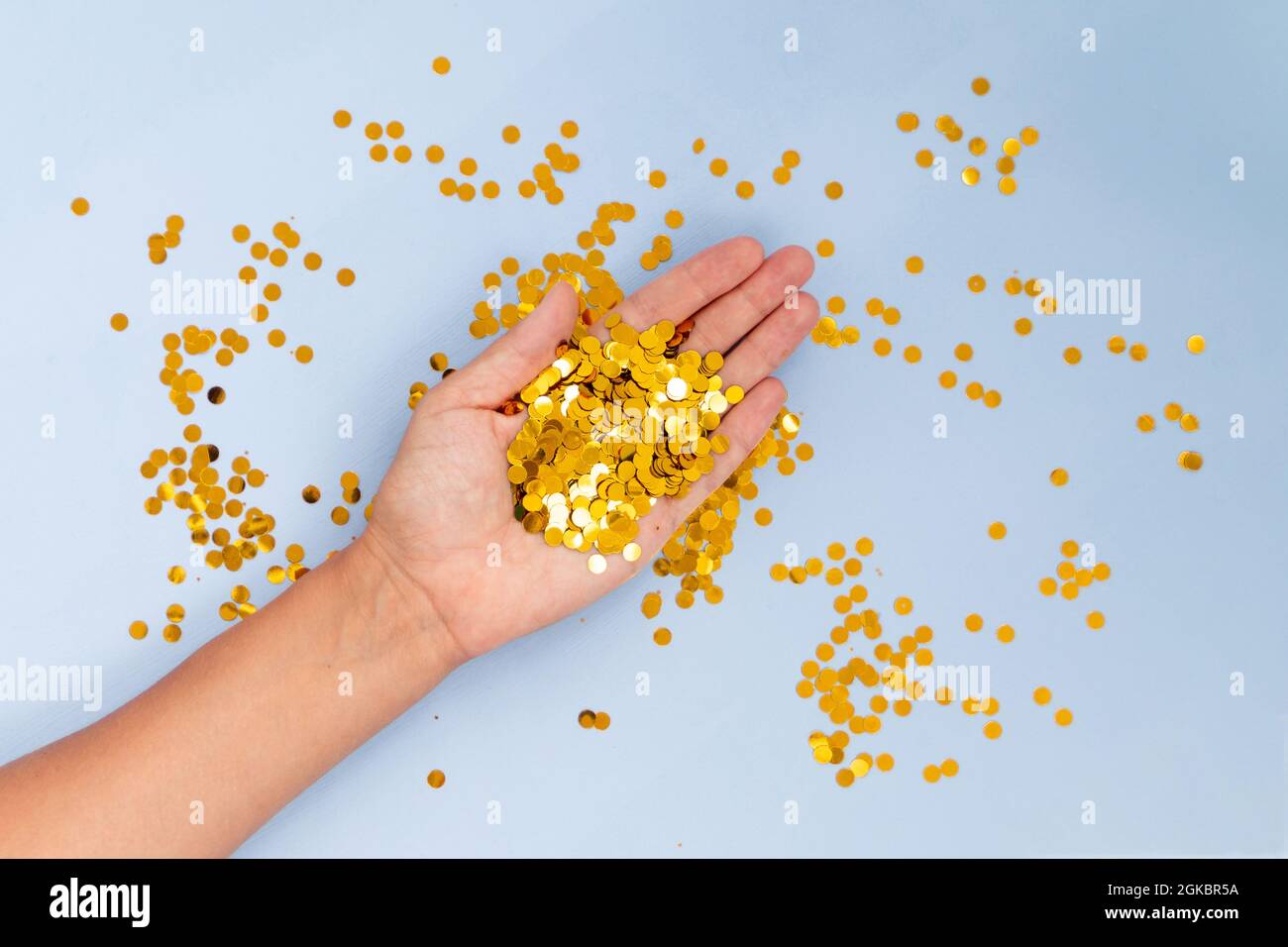 Light blue background with golden confetti, selective focus Stock Photo