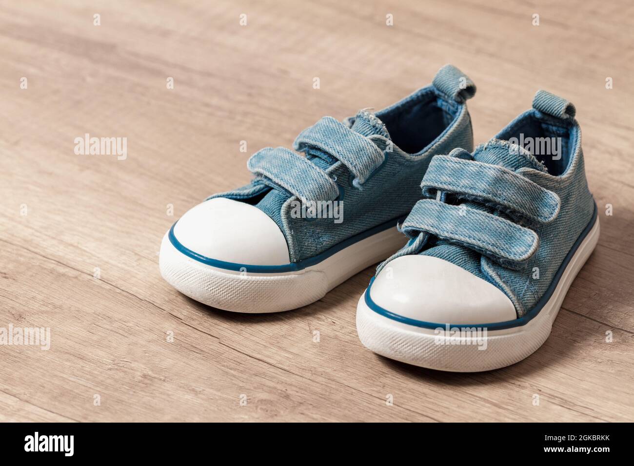 Children's sneakers of blue color on a wooden floor Stock Photo - Alamy