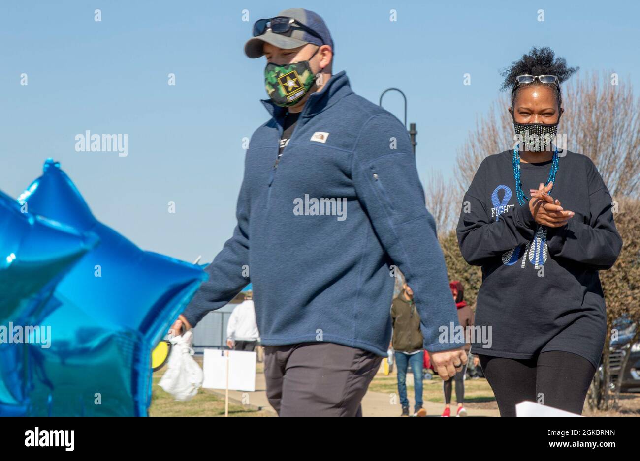 U.S. Army Soldier Sgt. 1st Class Jewel Lott, a colon cancer survivor and awareness organizer assigned to the 120th Infantry Brigade, Division West, walks across the finish line with one of her supporters, during a colon cancer awareness walk on March 6 at Lions Club Park, Killeen, Texas. While March is colon cancer awareness month, Lott has started a new journey of supporting her community by organizing an annual walk for colon cancer. Stock Photo