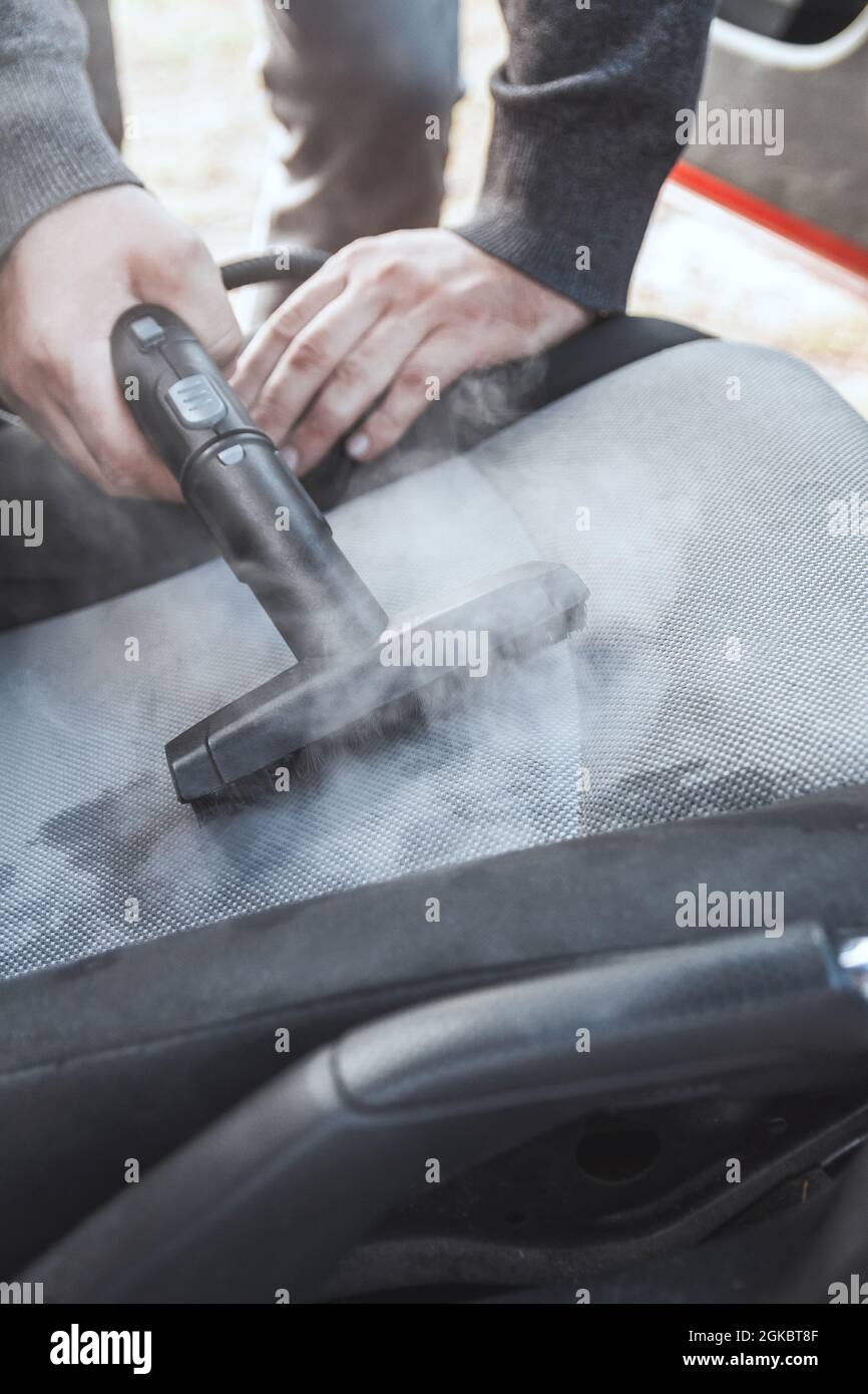 a man cleaning car interior by use foam chemical and scrubbing machine  Stock Photo - Alamy