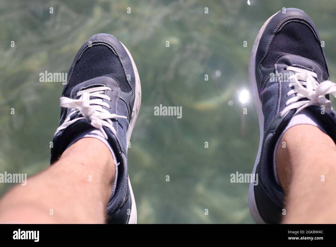 Feet hang above clear Water Stock Photo - Alamy