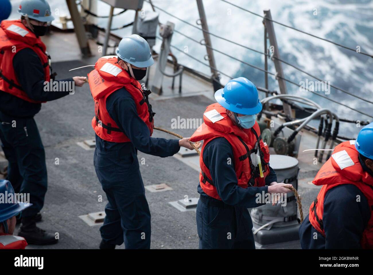 210307-N-QD512-1243 ATLANTIC OCEAN (March 7, 2021) Sailors heave in line aboard the Arleigh Burke-class guided-missile destroyer USS Mitscher (DDG 57) during a replenishment-at-sea with the Supply-class fast combat supply support ship USNS Arctic (T-AOE 8), March 7, 2021. Mitscher is operating with the Ike Carrier Strike Group on a routine deployment in the U.S. Sixth Fleet area of operations in support of U.S. national interests and security in Europe and Africa. Stock Photo