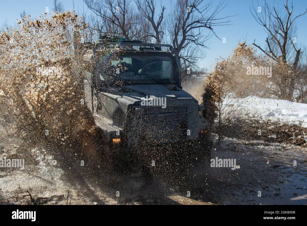 U.S. Marines drive a medium tactical vehicle replacement through a low
