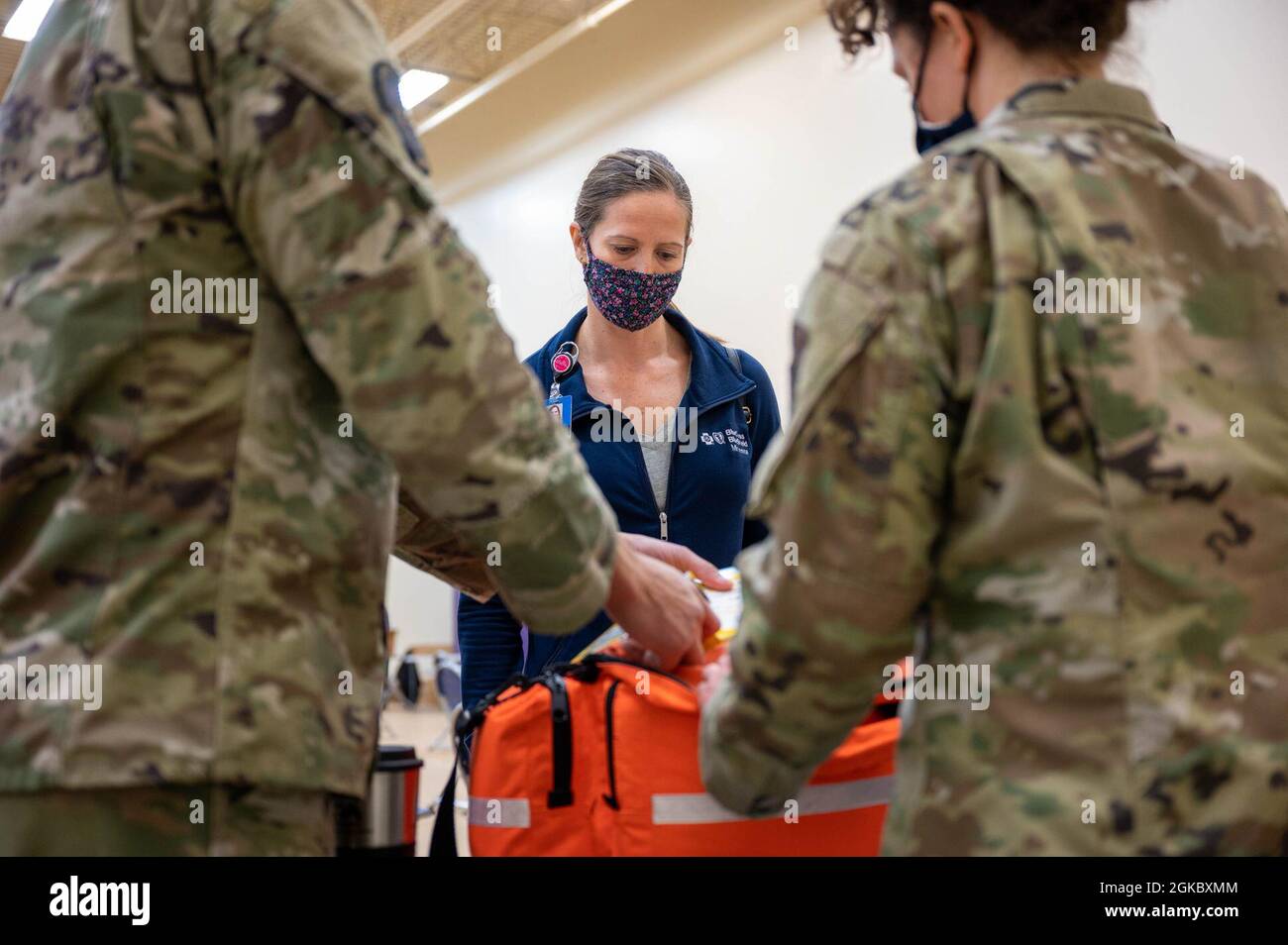 Nicole Nee, a case manager with Blue Cross/Blue Shield, watches a demonstration of first aid equipment at the vaccine dispensation site at he Minneapolis-St. Paul Air Reserve Station, March 7, 2021. First aid is available in the event a patient who has received the vaccine should develop a negative reaction. Stock Photo