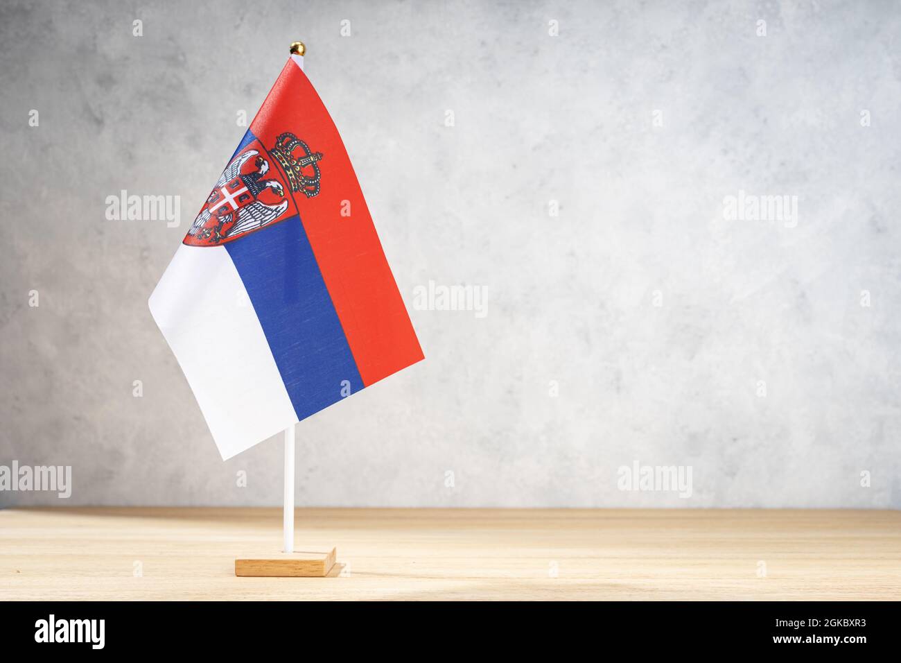 Serbia table flag on white textured wall. Copy space for text, designs or drawings Stock Photo