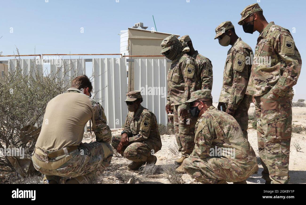 U.S. Army Soldiers from 318th Chemical Company, 1st Battalion, 35th Armored Regiment, 2nd Brigade, 1st Armored Division, Task Force Spartan, inspect a simulated improvised explosive device with an Explosive Ordinance Disposal training instructor, March 7, 2021, during an IED identification class near Doha, Qatar. The 318th Chemical Company out of Birmingham, Alabama, trained with other U.S. forces during U.S. Central Command’s exercise Invincible Sentry. The annual bilateral exercise is designed to strengthen military-to-military relationships and regional security in Southwest Asia. Stock Photo