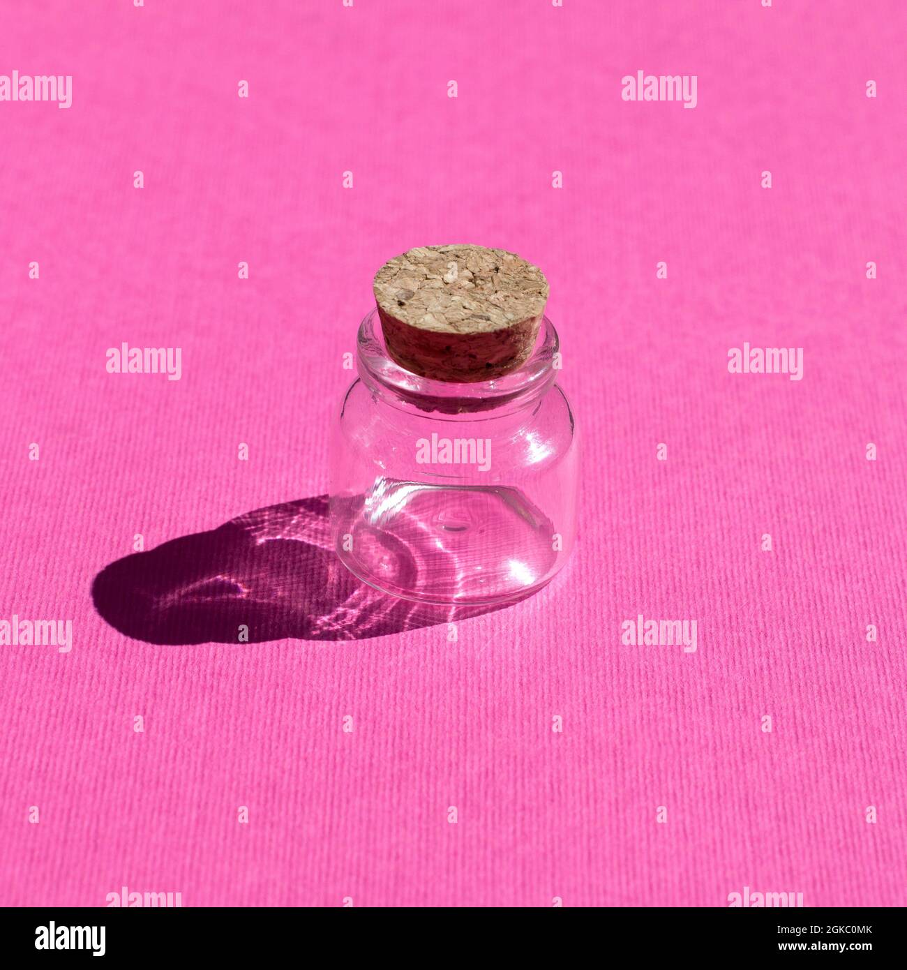 Empty little bottles with cork stopper on pink background front view Stock Photo