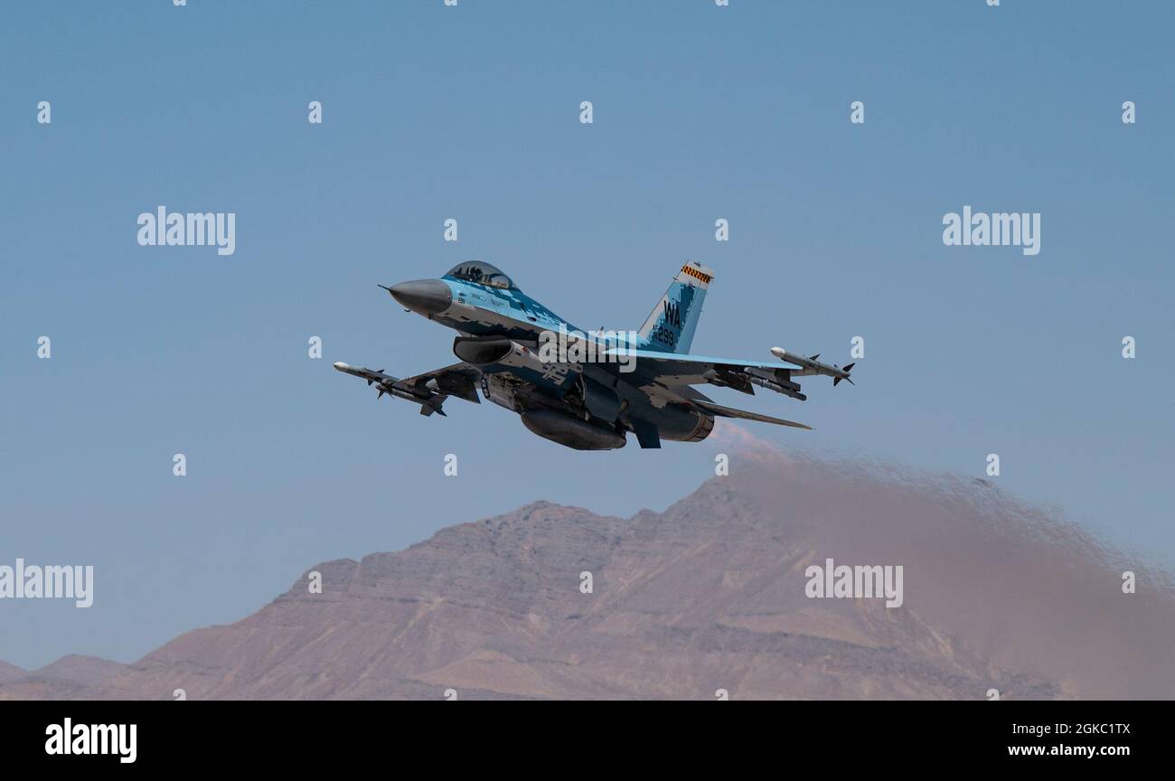An F-16C Falcon fighter jet assigned to the 64th Aggressor Squadron, takes-off for a Red Flag 21-2 mission at Nellis Air Force Base, Nevada, March 8, 2021. The Aggressor’s primary mission is to prepare the combat air forces, joint, and allied aircrews with realistic and challenging threat replication, training and feedback. Stock Photo