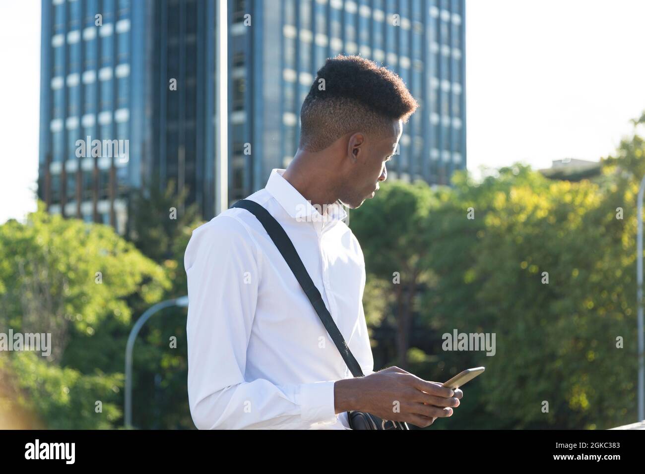 young afroamerican businessman with briefcase using phone in city Stock Photo