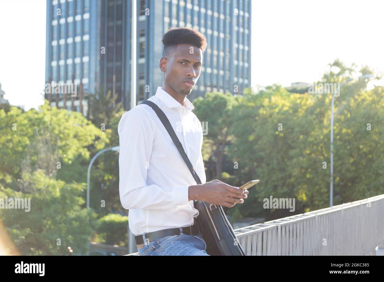young afroamerican businessman with briefcase using phone outdoor Stock Photo