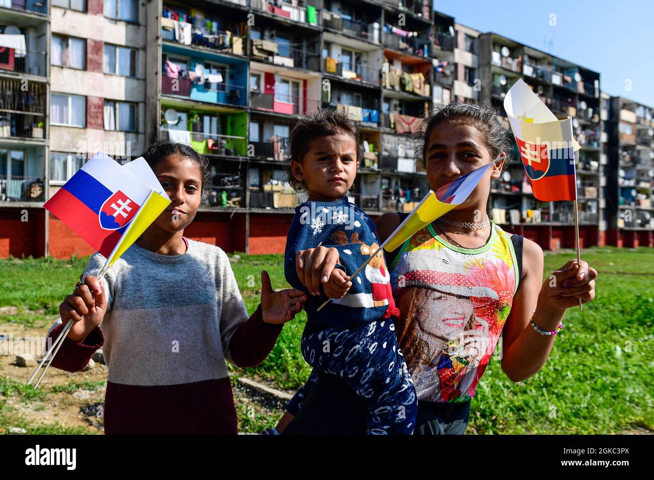 Young girls holding Slovak and Vatican flags await the Pope Francis, who will meet local Roma minority at biggest Slovak Roma housing estate Lunik IX in Kosice today, on Tuesday, September 14, 2021, during his four-day visit to Slovakia, which started on Sunday. (CTK Photo/Roman Vondrous) Stock Photo
