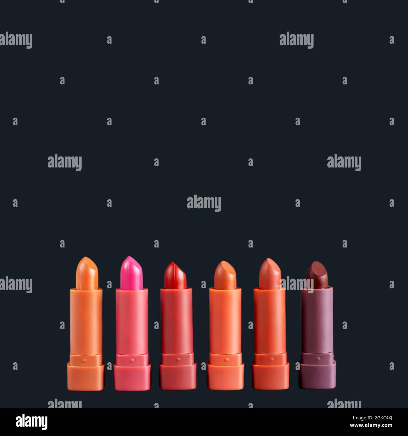 Set of fashion lipsticks palette in red, brown and pink colors, studio photo on black background. Beautiful make-up or cosmetic sale concept Stock Photo