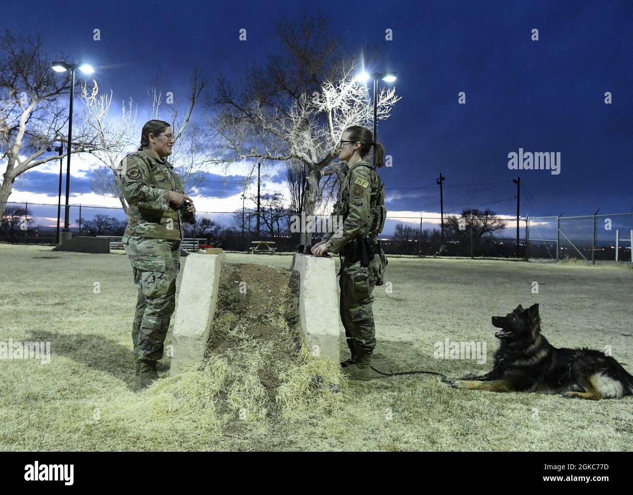 U.S. Air Force Staff Sgt. Adrienne G. Dunham, left, and Staff Sgt. Tara C. Cummins, right, both 377th Security Forces Squadron military working dog (MWD) handlers, prepare to conduct training with MWD Hugo on Kirtland Air Force Base, New Mexico, March 9, 2021. Cummins, MWD Hugo’s handler, trains Hugo each shift to ensure he is comfortable around gunfire and can complete any mission. Stock Photo