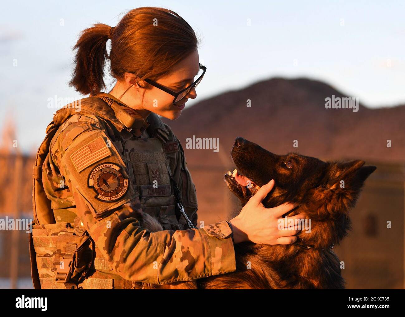 U.S. Air Force Staff Sgt. Tara C. Cummins, 377th Security Forces Squadron military working dog (MWD) handler, greets MWD Hugo on Kirtland Air Force Base, New Mexico, March 9, 2021. Cummins is only one of two female dog handlers who work on Kirtland. Stock Photo