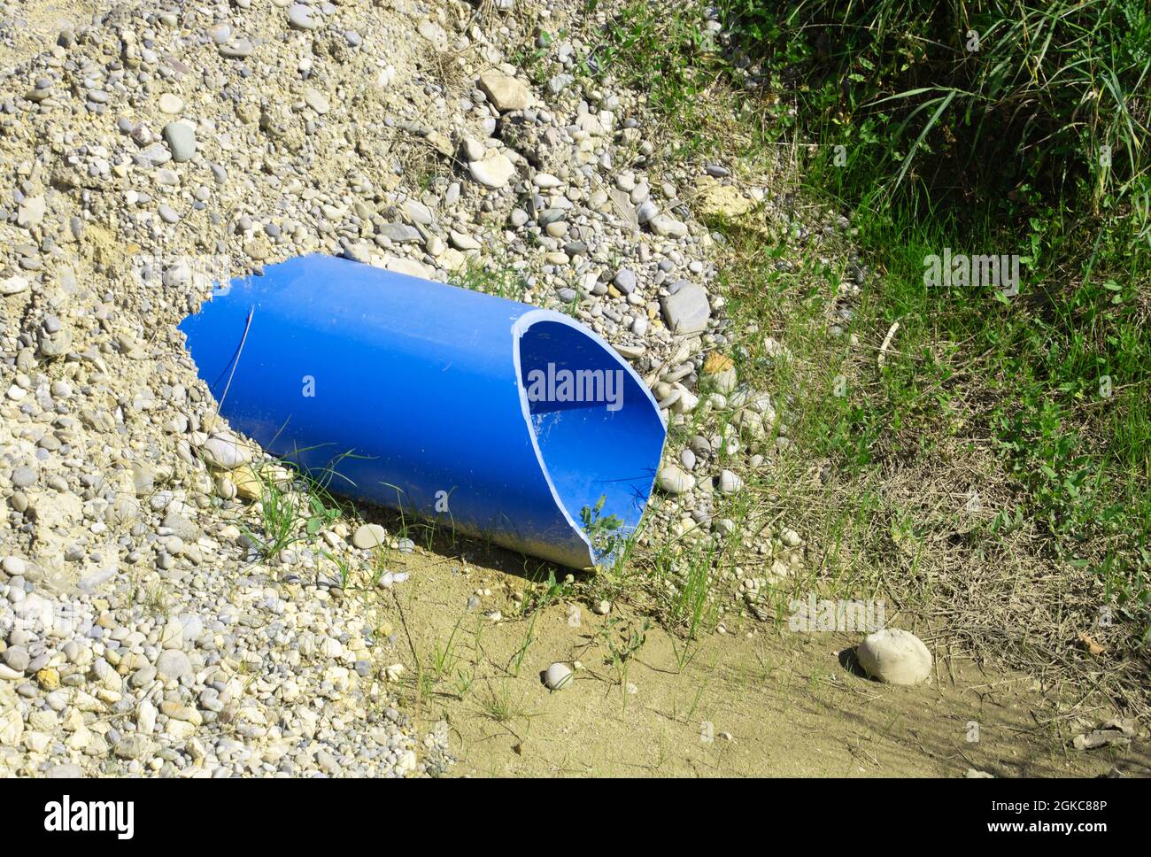laying blue PVC water pipe under backfilling gravel under tar street