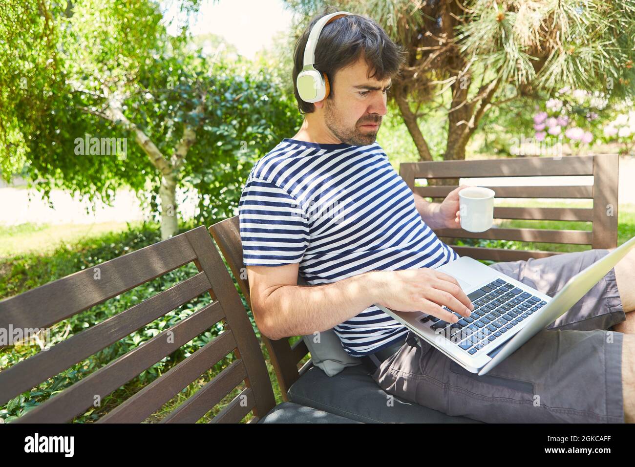 Freelancer man working on laptop computer in green garden in summer on ...