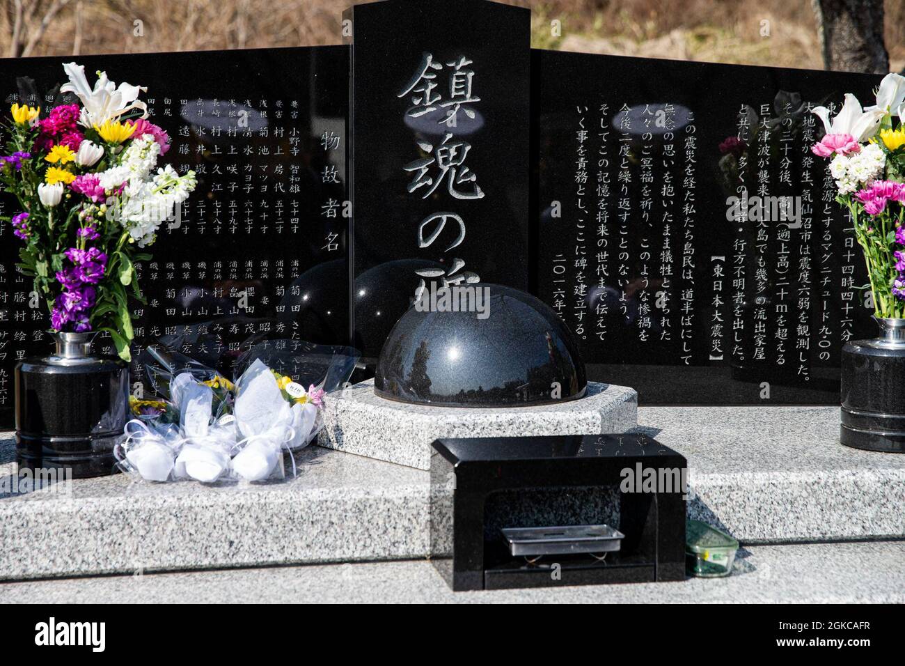 Marine Corps Installations Pacific key leaders gather around a memorial on Oshima Island, Japan, March 11, 2021. The memorial recognizes the 33 people from Oshima Island who lost their lives in the 2011 Great East Japan earthquake and tsunami. Stock Photo