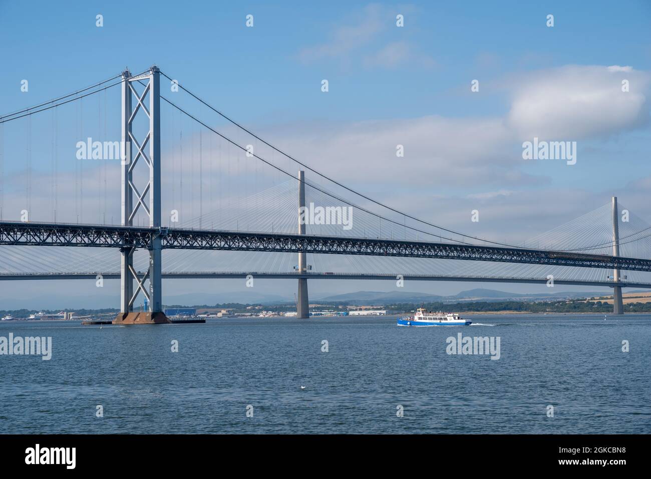 South Queensferry, Edinburgh, Scotland 7th September 2021 - View of the Forth Road Bridge and Queensferry Crossing with a Ferry Boat on a sunny day Stock Photo