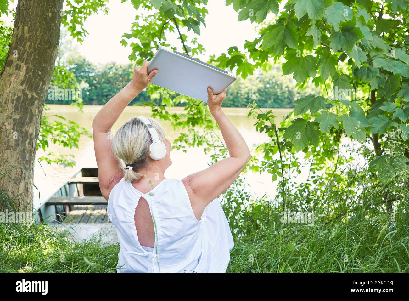Business woman holding laptop computer with both hands up on summer vacation Stock Photo