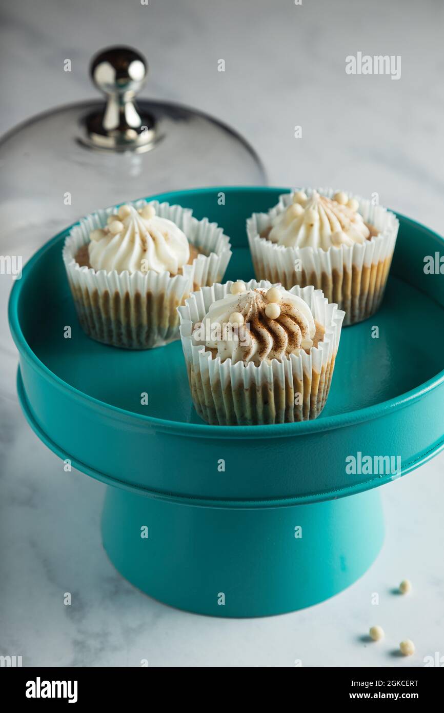 Three mini pumpkin cheesecakes on a teal cake tray. Stock Photo