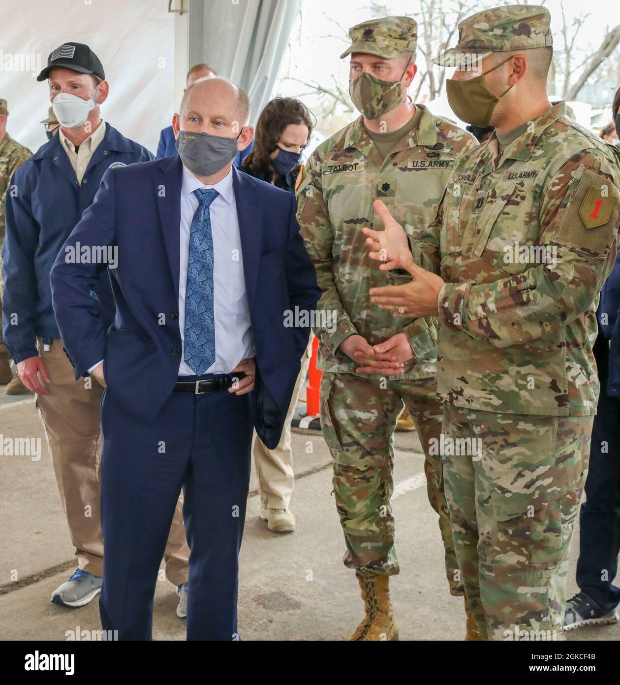 Honorable John E. Whitley, Acting U.S. Secretary of the Army, and U.S. Army Lt. Col. Nicholas Talbot, 1st Battalion, 63rd Armor Battalion, 2nd Armored Brigade Combat Team, 1st Infantry Division, commander, speak with U.S. Army Cpt. Anthony Davila, Bravo Company, 1st Combined Arms Battalion, 63rd Armor Battalion, 2nd Armored Brigade Combat Team, 1st Infantry Division, commander, at the Fair Park Community Vaccination Center (CVC) in Dallas, March 12, 2021. Davila discussed CVC operations and how U.S. Army 1st Infantry Division Soldiers were working to assist the Federal Emergency Management Age Stock Photo