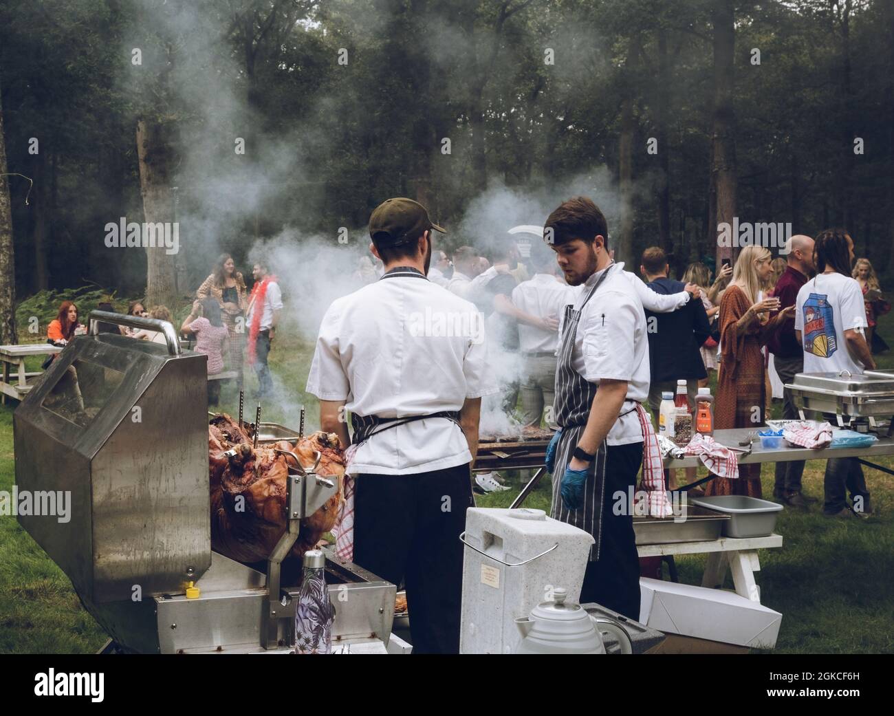 chefs cooking a hog roast at an outdoor event Stock Photo