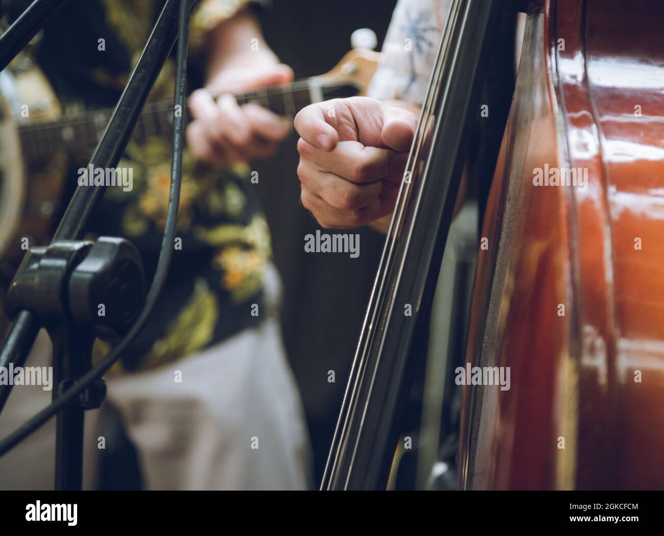 a closeup of a member of a bands hand playing a double bass Stock Photo