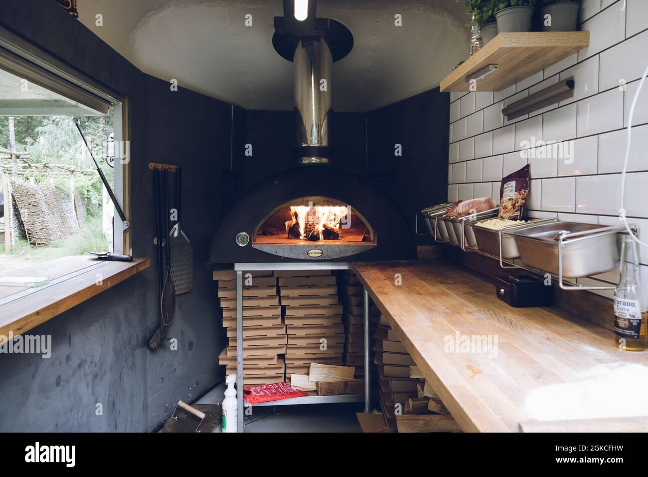 a mobile kitchen with a pizza oven burning inside Stock Photo