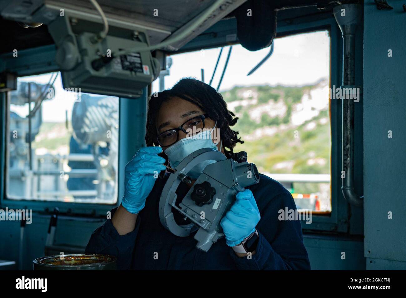210312-N-WQ732-5007 SOUDA BAY, Greece (March 12, 2021) Quartermaster 3rd Class Pashawn Hunt, from Franklin, Virginia, greases a telescopic alidade aboard the Ticonderoga-class guided-missile cruiser USS Monterey (CG 61), March 12, 2021.  Monterey is operating with the Ike Carrier Strike Group on a routine deployment in the U.S. Sixth Fleet area of operations in support of U.S. national interests and security in Europe and Africa. Stock Photo
