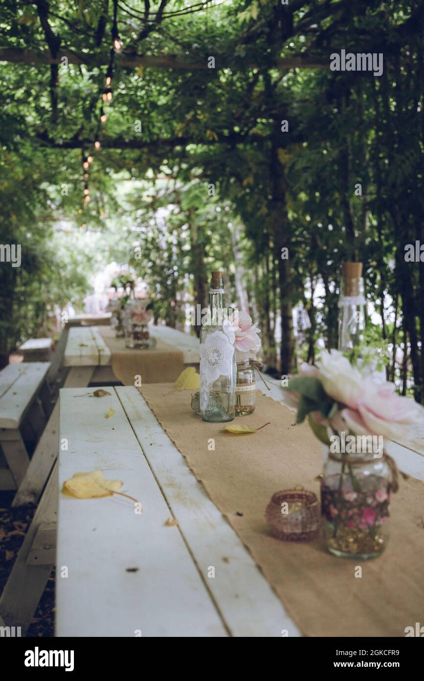 wooden tables laid with wedding decorations Stock Photo