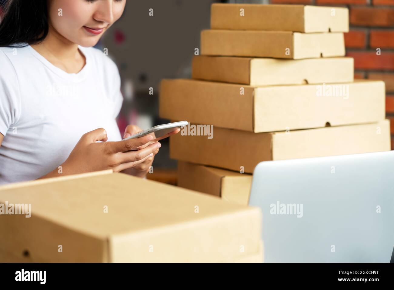 Delivery Mail Shipping  work space with computer laptop and cellphone the Delivery Box. Packing Accessories Cardboard Parcel Box for Online Selling. E Stock Photo