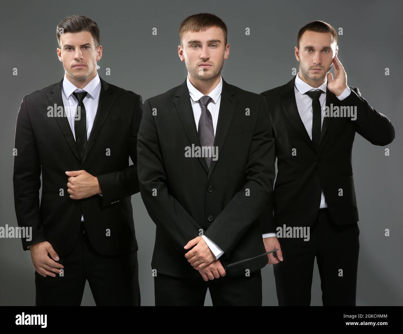 Handsome bodyguards on grey background Stock Photo Alamy