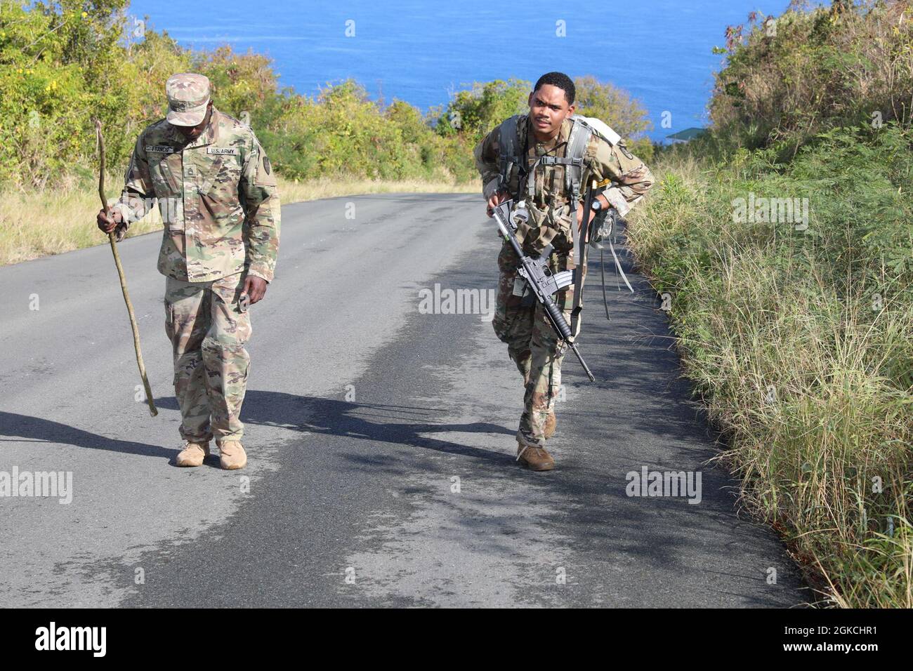 Pfc. Eddison Lewis (right), 786th HHC, makes his way through the 12-mile ruck march during the Best Warrior Competition, March 13, 2021.    The Virgin Islands National Guard BWC is a culminating test where the competing NCOs and soldiers spend five days competing in various challenges, including firing weapons, land navigation, the Army Physical Fitness Test, and other various events. These challenges will test each competitor's knowledge, technical and tactical skills, physical endurance, mental toughness, and overall combat readiness. Stock Photo