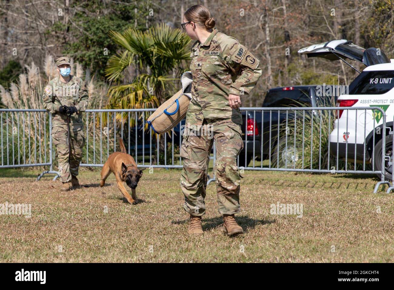 Spc. Catalino Lopez, left, Military Working Dog Alex and Spc. Kaylie Buck, all assigned to 93rd Military Working Dogs Detachment, 385th Military Police Battalion, participate in a MWD demonstration, March 13, 2021, at Holbrook Pond in Fort Stewart, Georgia. The 93rd MWD Det. supports the U.S. Forces Command and U.S. Secret Service missions by performing specialized security patrols and detecting explosives and narcotics. Stock Photo