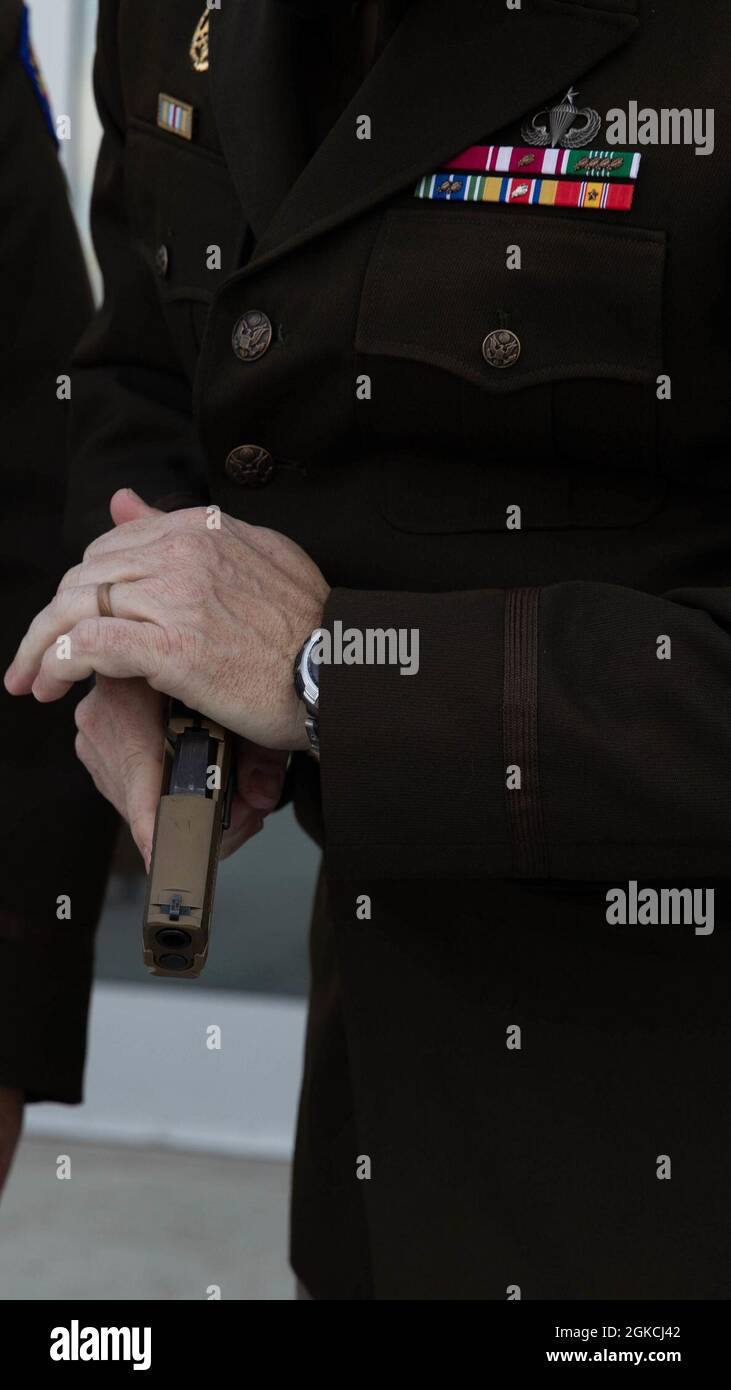 U.S. Army Brig. Gen. Robert Wooldridge, deputy commander of support for the 40th Infantry Division, California National Guard, inspects the M18 pistol he received during his promotion ceremony at Joint Forces Training Base, Los Alamitos, California, March 13, 2021. Stock Photo