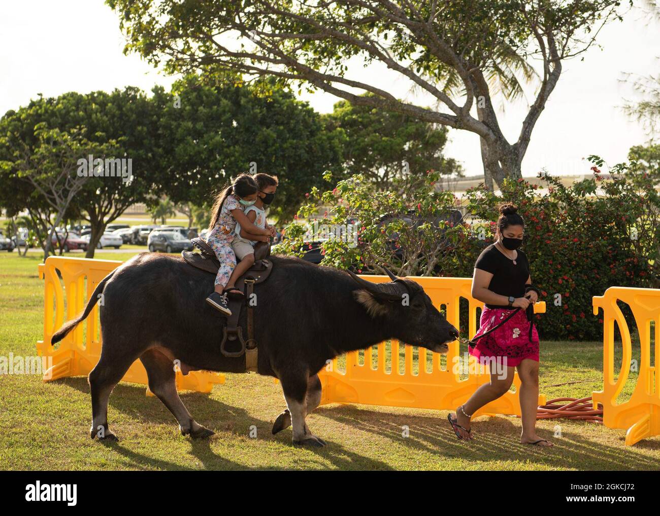 A guide leads a carabao ride for two children during the Tåotåo Guåhan ...