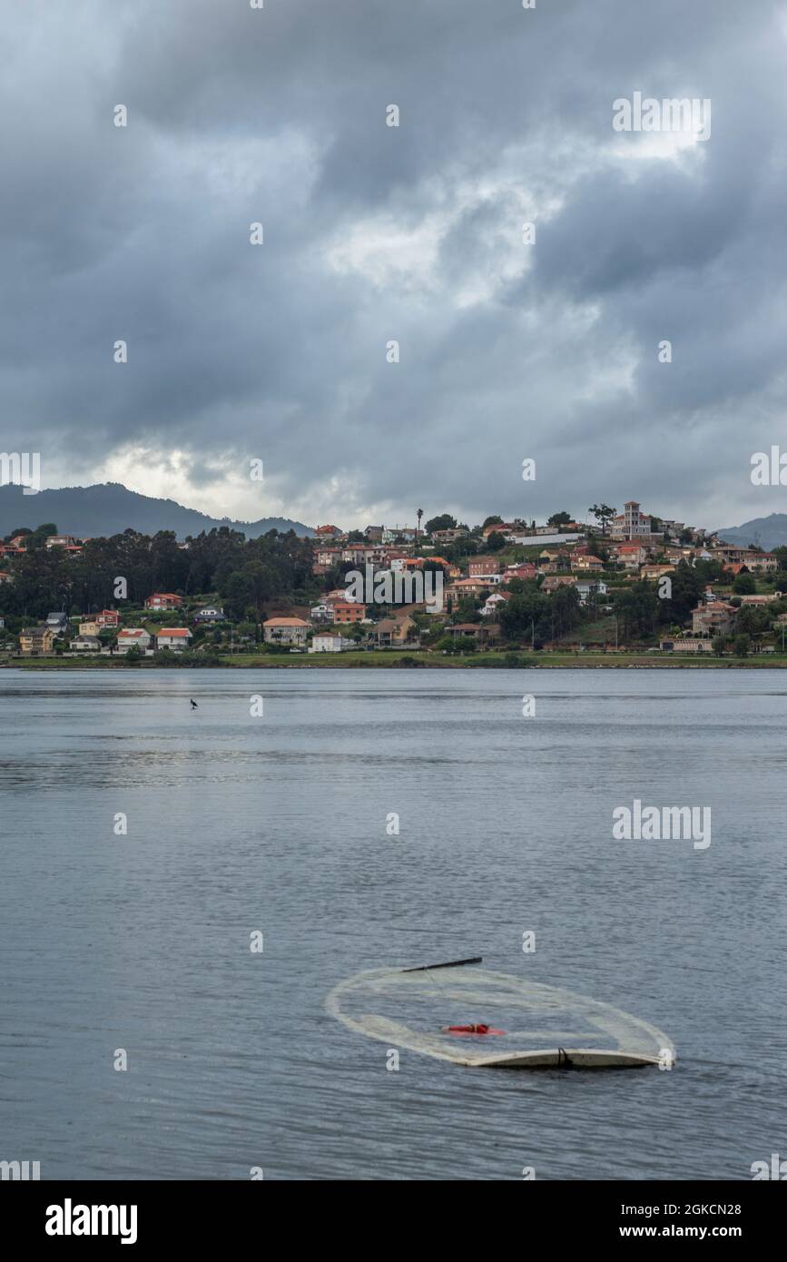 Sunken raft in the bay with a cormoran in the background and the town ...