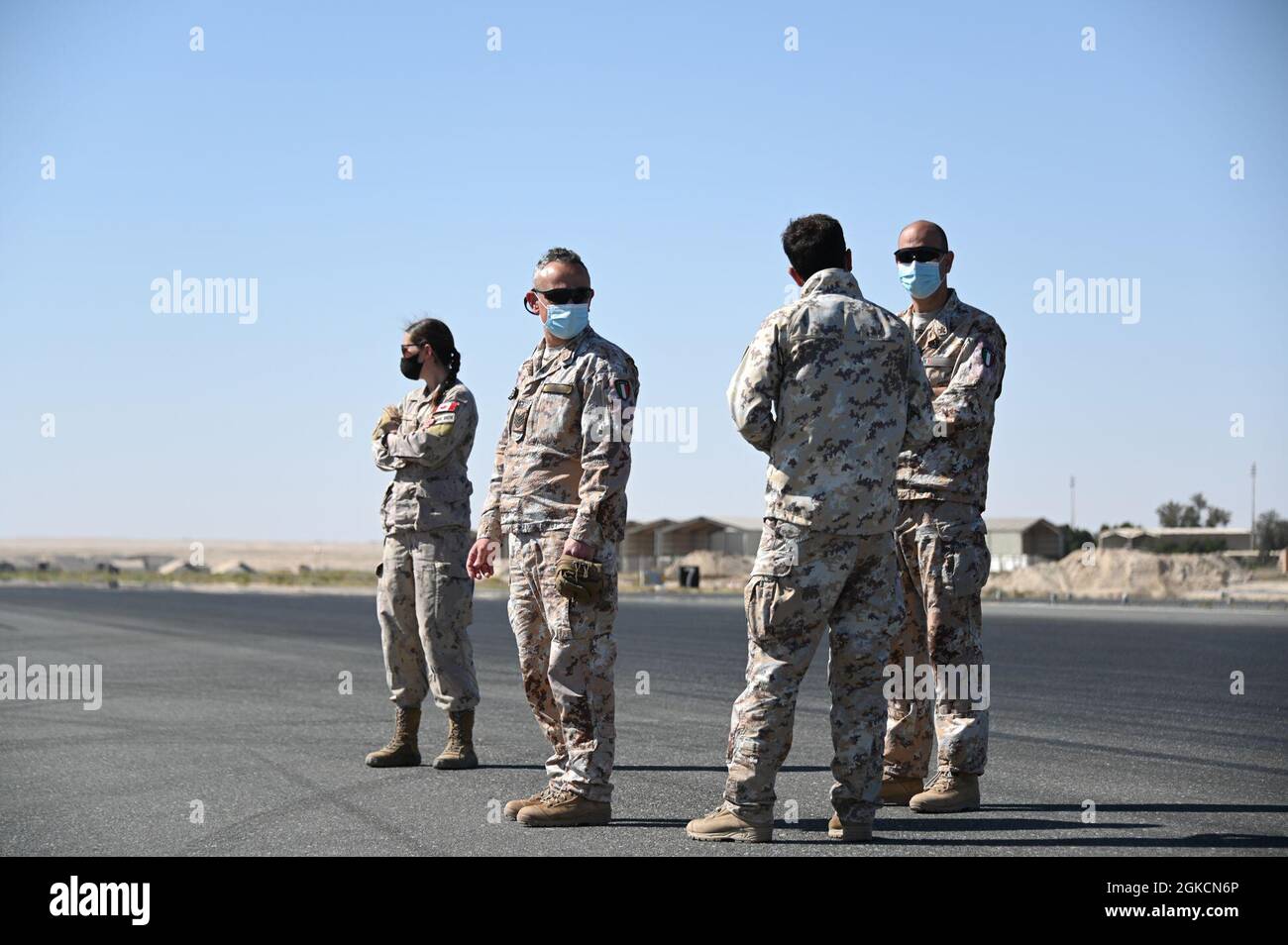 Italian air force airmen speak during a concrete pour at Ali Al Salem Air Base, Kuwait, March 14, 2021. Members assigned to the 386th Expeditionary Civil Engineer Squadron worked with joint and coalition partners to begin building a mobile aircraft arresting system. The MAAS is an emergency braking system for tail-hook-equipped aircraft. Stock Photo