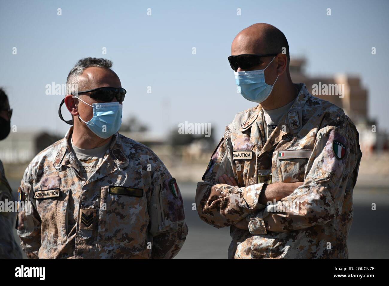 Italian air force members speak during a concrete pour at Ali Al Salem Air Base, Kuwait, March 14, 2021. Members assigned to the 386th Expeditionary Civil Engineer Squadron worked with coalition partners to begin building a mobile aircraft arresting system. The MAAS is an emergency braking system for tail-hook-equipped aircraft. Stock Photo