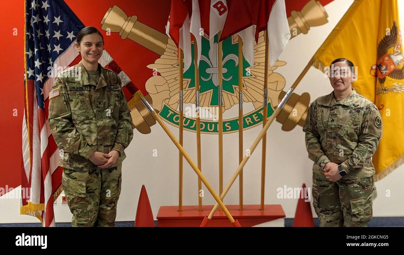 U.S. Army Sgt. Jennifer Ponce and Sgt. Kelley Chilauskas stand in front of  the unit colors