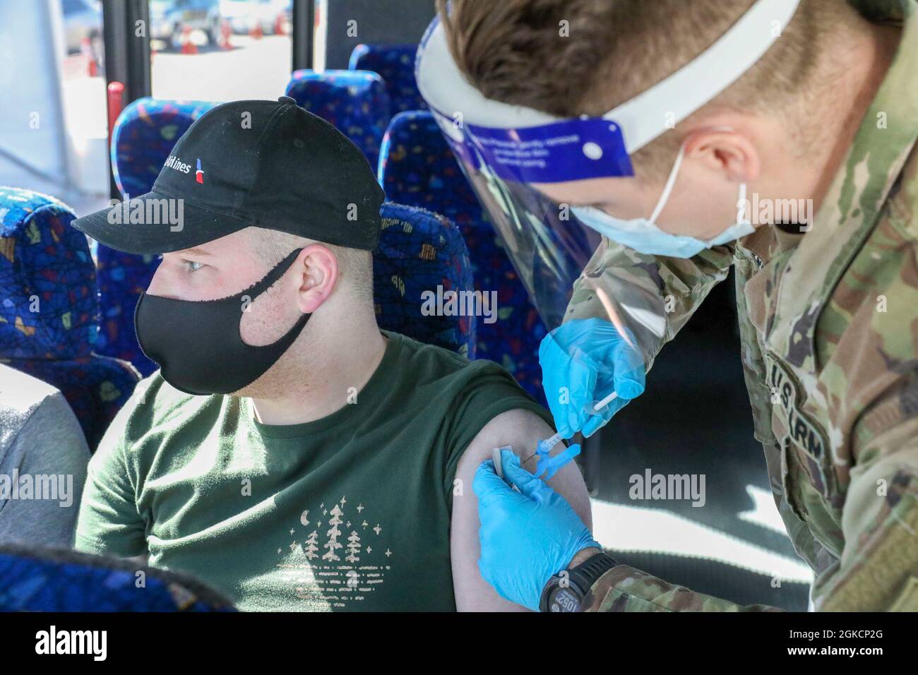U.S. Army Spc. Joshua Thompson, a combat medic with 82nd Brigade Engineer Battalion, 2nd Armored Brigade Combat Team, 1st Infantry Division, administers a COVID-19 vaccination to Lucas Vines, a Euless, Texas, community member, at the Fair Park Community Vaccination Center (CVC) in Dallas, March 15, 2021. 1st Infantry Division Soldiers were deployed to Dallas from Fort Riley, Kansas, and vaccinated local community members that were transported to the CVC by the Federal Emergency Management Agency (FEMA) from underserved Dallas areas. U.S. Northern Command, through U.S. Army North, remains commi Stock Photo