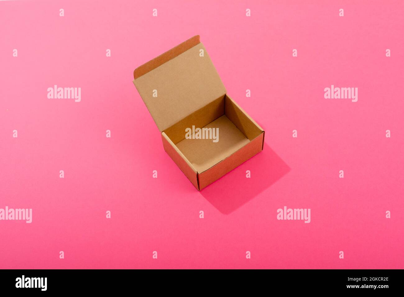 Composition of open empty cardboard gift box on pink background Stock Photo